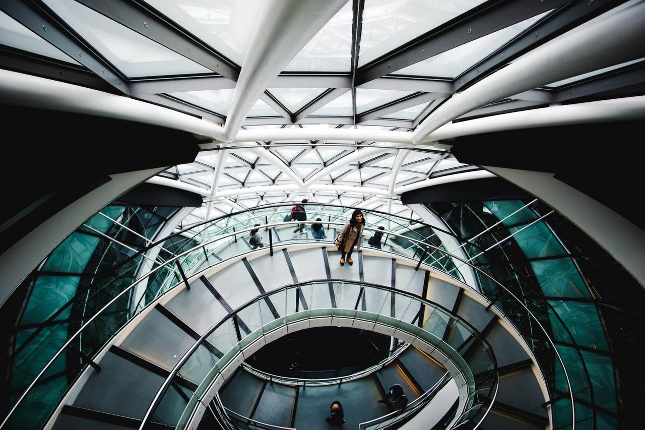 An internal view of the Gherkin looking down onto stairs with people standing and walking on them