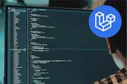 A person is seated in front of a computer monitor displaying lines of code in a dark theme. The code includes various programming elements, such as functions and variables, with syntax highlighting in different colours. In the top right corner, there is a blue circular logo with a white geometric design resembling three-dimensional blocks, possibly representing a software framework. The background appears blurred, suggesting a workspace environment.