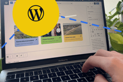 Wordpress cms on laptop with a large yellow circle containing the WordPress logo and blue beams radiating out. Wordpress website design agency​