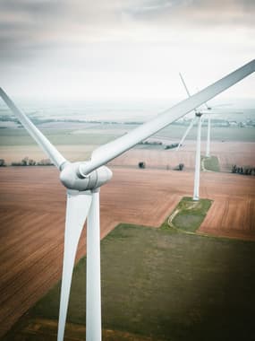 A field with large wind turbines in a line