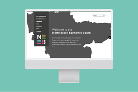 NEEB website homepage on a computer with a mint background