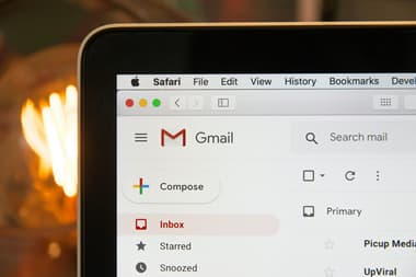 A photo showing Gmail open on an Apple laptop, with the top left of the screen in view shown in close up