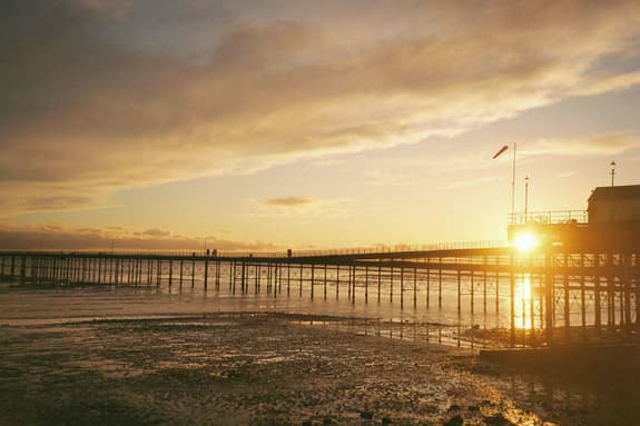 A photo of Southend Pier at sunset with the tide going out