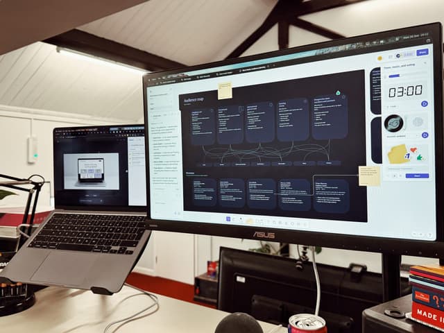a monitor and laptop showing customer journey planning and persona mapping in figma