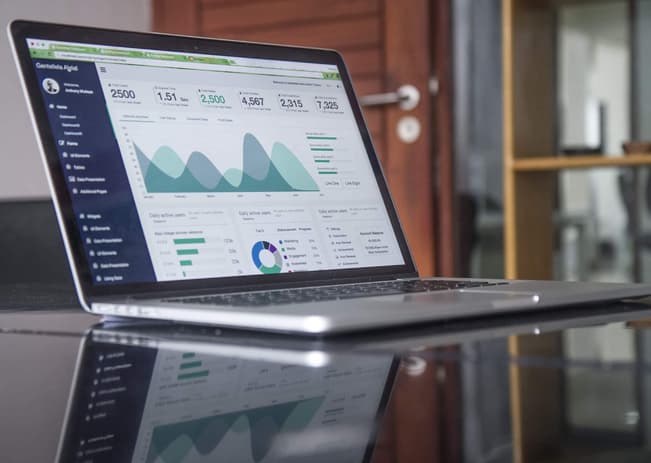 SEO results for a website shown on a laptop screen, which is on a reflective desk surface