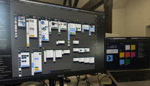 Deskspace with laptop and monitor on showing figma designs for kings health partners